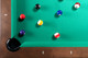 Overhead view of the Doc & Holliday Luxury Billiard Ball Set on Championship green felt, with Mother-of-Pearl sights on the Paula Parsons Slate Pool Table. Overhead view of the Doc & Holliday Luxury Billiard Ball Set on Championship green felt, with Mother-of-Pearl sights on the Paula Parsons Slate Pool Table.